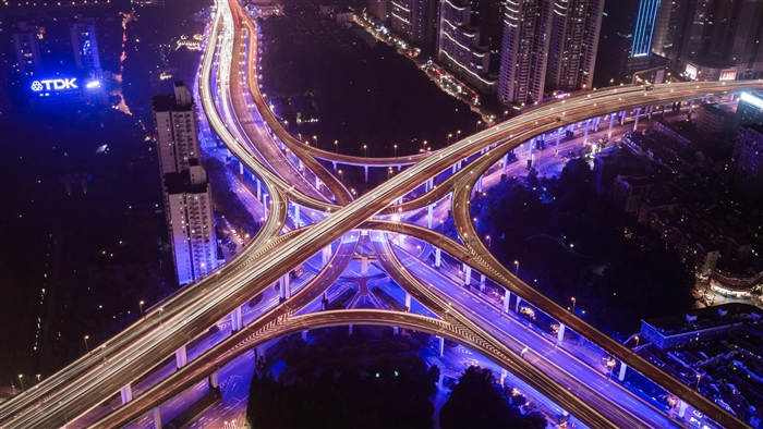Aerial view of a brightly lit city highway interchange at night