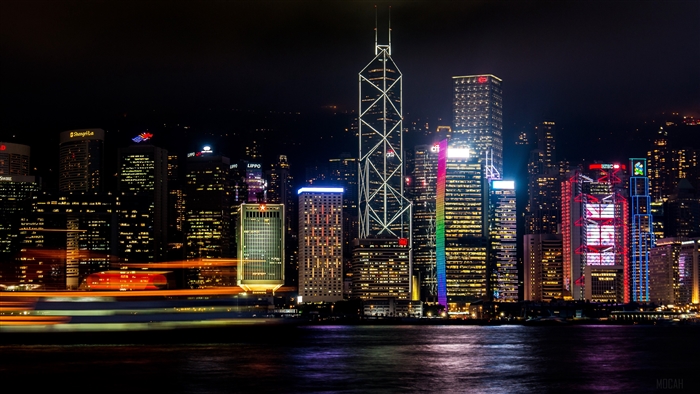Hong Kong skyscrapers at night with a ferry