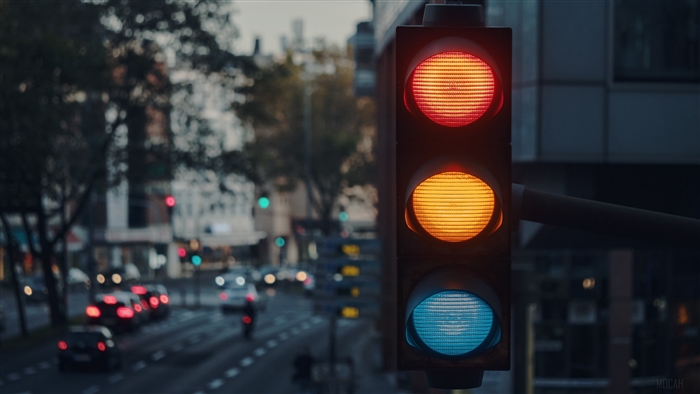 Traffic light in a city with cars