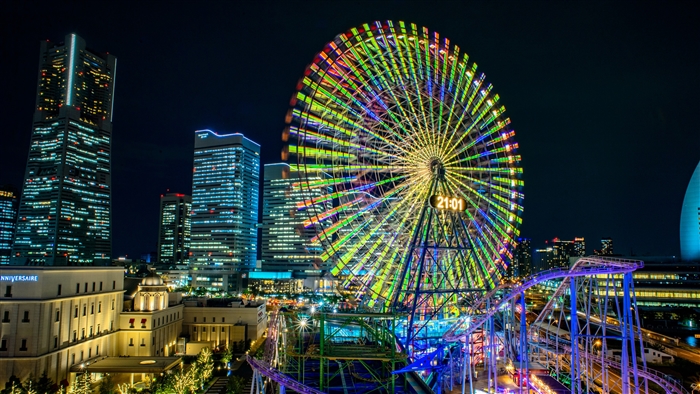 Night view of a colorful Ferris wheel and skyscrapers