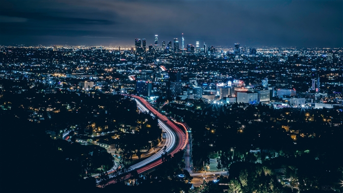 Los Angeles cityscape at night with light trails on highway