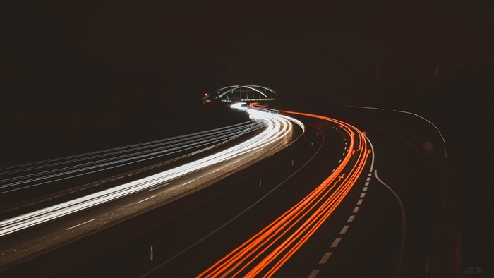 Night highway with light trails and bridge