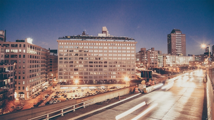 City skyline at night with highway traffic