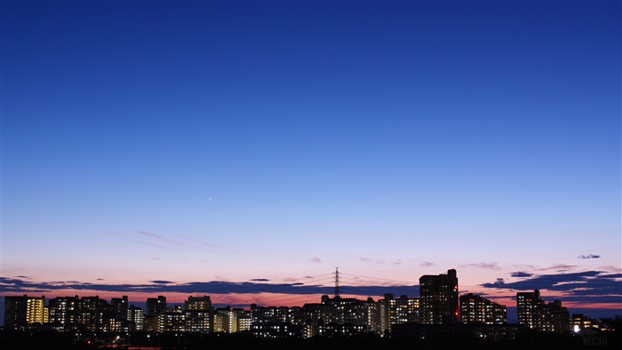 City skyline at dusk with a clear blue sky