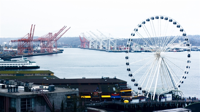 Ferris wheel and port with cranes on the sea 4K