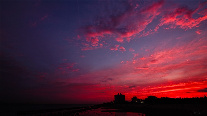 Sunset over a city skyline with red clouds
