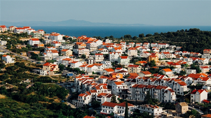 Cityscape with red-roofed buildings and the sea