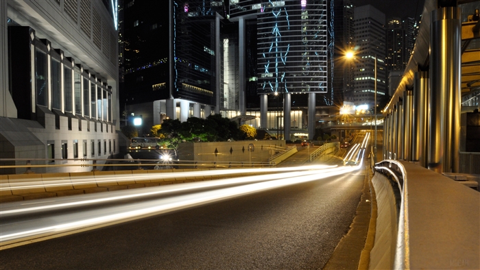 City road at night with light trails and skyscrapers