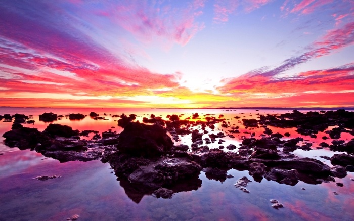 Colorful sunset over rocky shore and ocean
