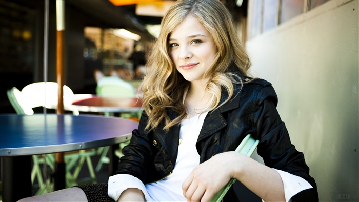 Chloe Moretz sitting at a table