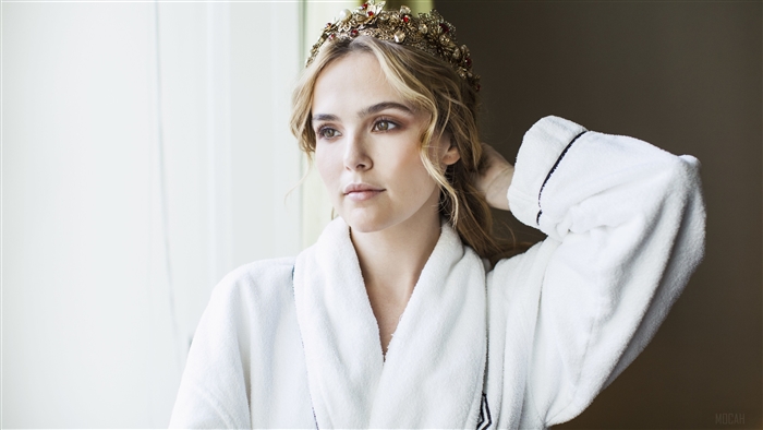 Zoey Deutch wearing a crown and robe