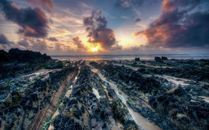 Rocky beach at sunset with dramatic clouds