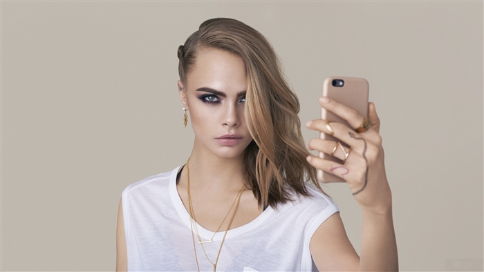 Cara Delevingne taking a selfie with a phone