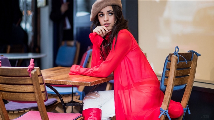 Camila Cabello sitting at a cafe table