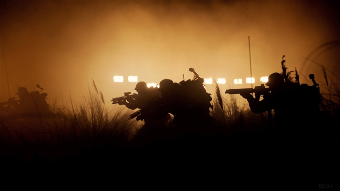 Soldiers in silhouette with spotlights in the background