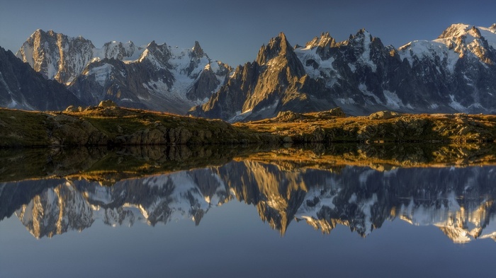 Snow-capped mountains reflected in a calm lake