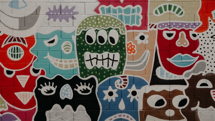 Graffiti art of colorful monster faces on a brick wall