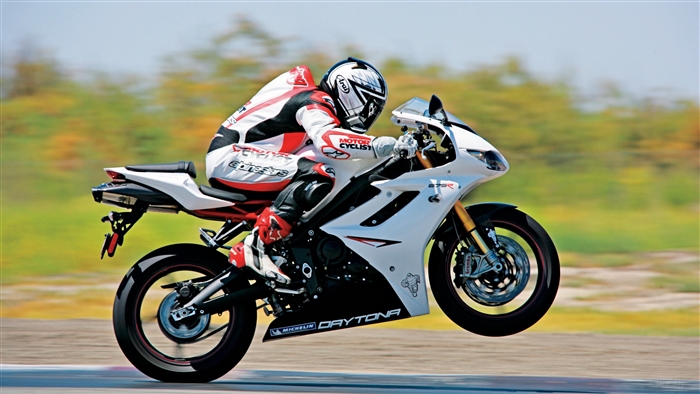 Motorcyclist performing a wheelie on a white Daytona motorcycle