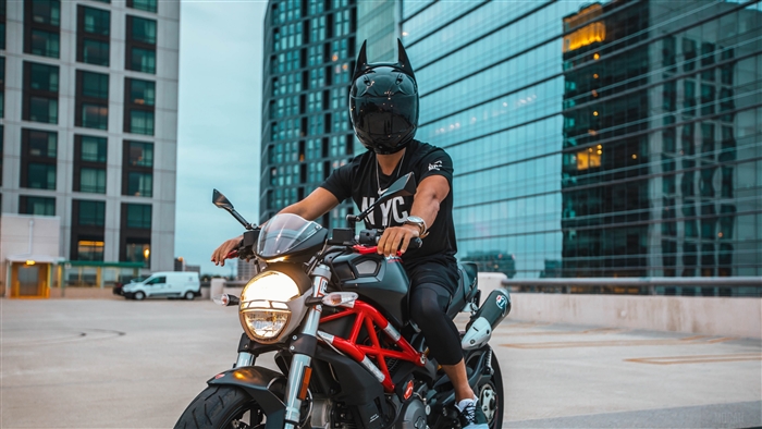 Man in Batman helmet on motorcycle in city 4K