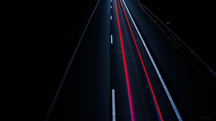Light trails on a dark highway at night