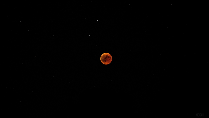 Red moon during an eclipse in a starry sky 4K