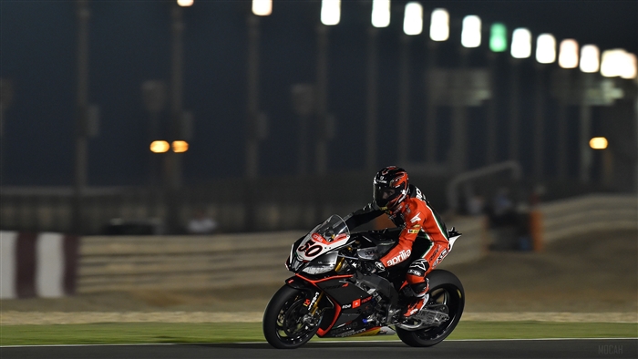 Motorcyclist racing on a track at night