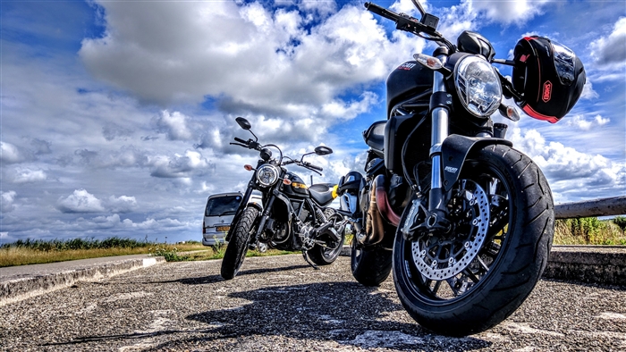 Two Ducati motorcycles with a helmet and a van