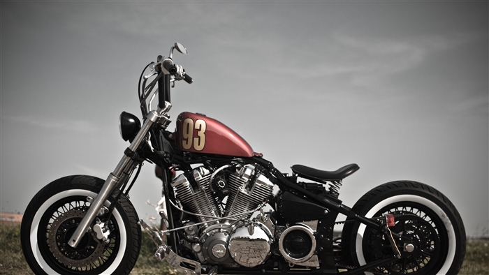 Red bobber motorcycle with '93' on the tank