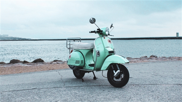 Mint green scooter parked by the sea