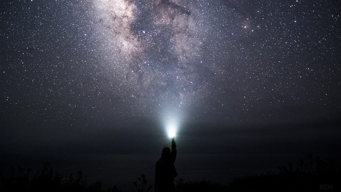 Man with flashlight under starry sky 4K