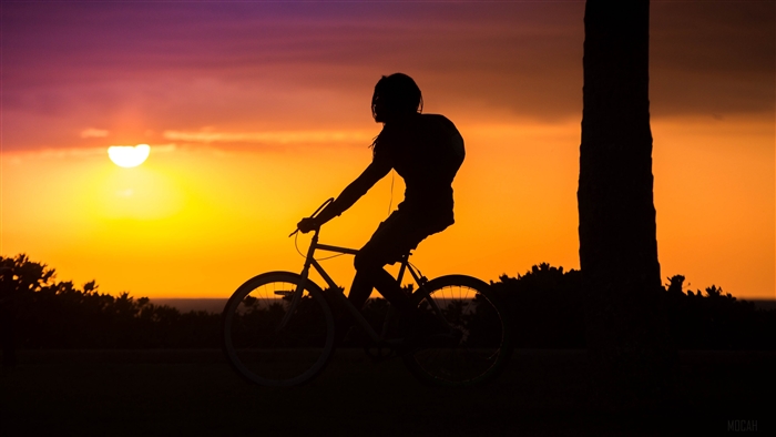 Cyclist silhouetted against a vibrant sunset