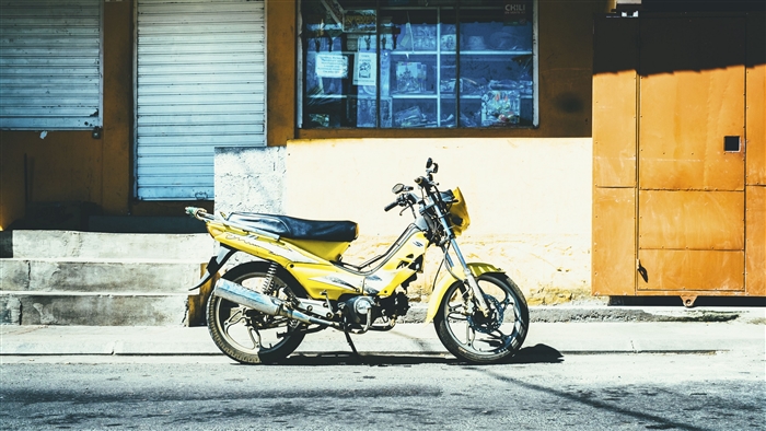 Yellow motorcycle parked on street