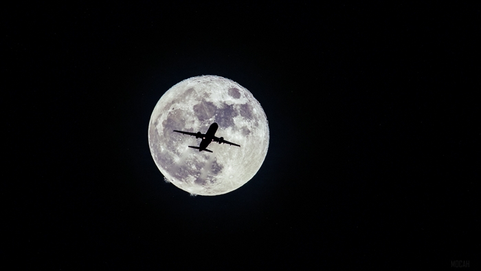 Airplane Silhouette Flying in Front of Full Moon