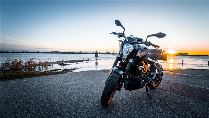 KTM motorcycle parked by flooded road at sunset