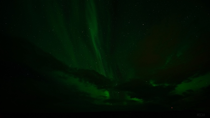 Aurora Borealis over starry sky with clouds