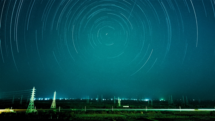 Star trails over power lines at night