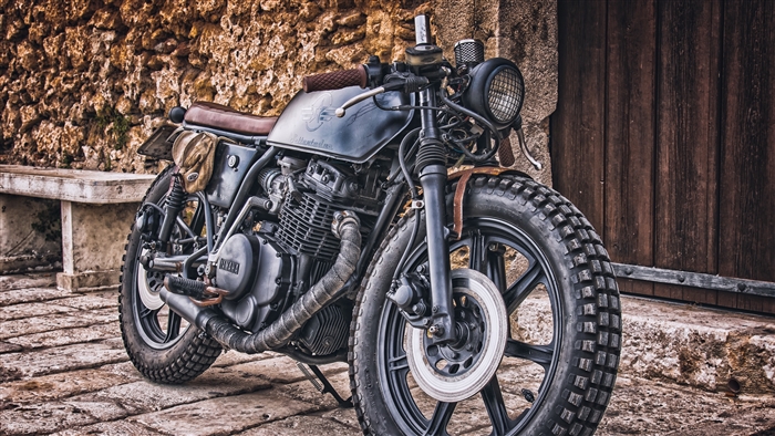 Yamaha motorcycle parked near stone wall