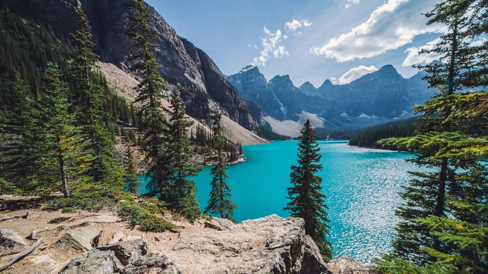 Turquoise lake surrounded by pine trees and mountains