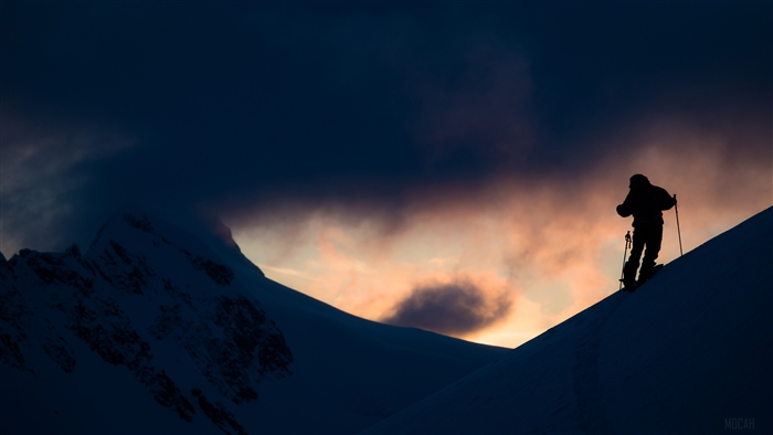Silhouette of skier on snowy mountain at sunset 4K