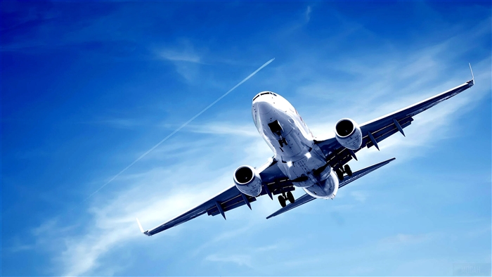 Airplane flying in blue sky with contrail