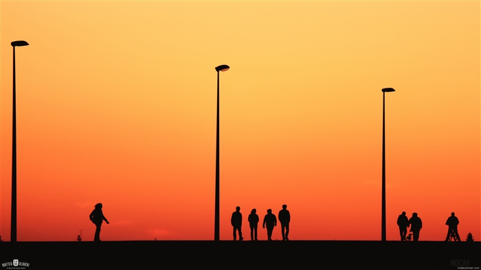 People Silhouetted Against Sunset Sky