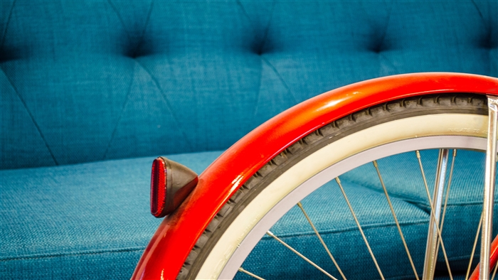 Red bicycle fender and wheel on blue couch