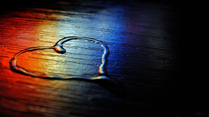Heart shape made of water on a wooden surface, 4K