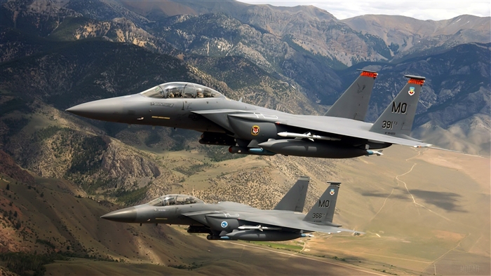 Two US Military F-15 fighter jets flying over mountains 4K