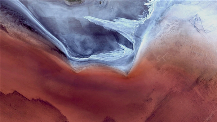 Aerial view of a desert landscape with red and blue hues