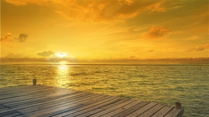 Sunrise over the ocean with a wooden pier