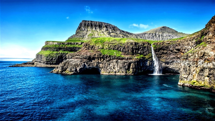 Waterfall on a grassy cliff in the Faroe Islands 4K
