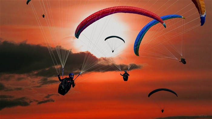 Paragliders flying in the sky during sunset