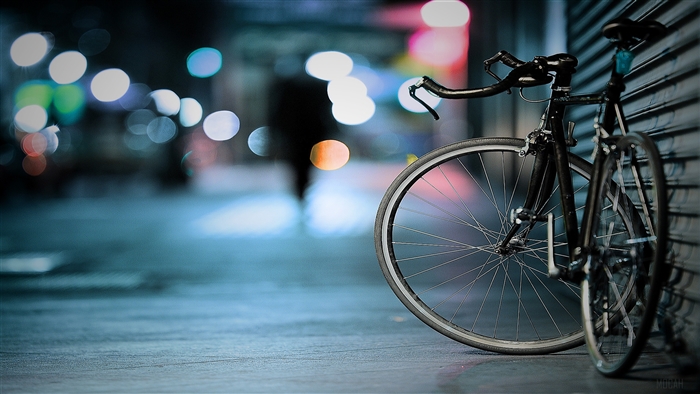 Bicycle parked on a city street at night