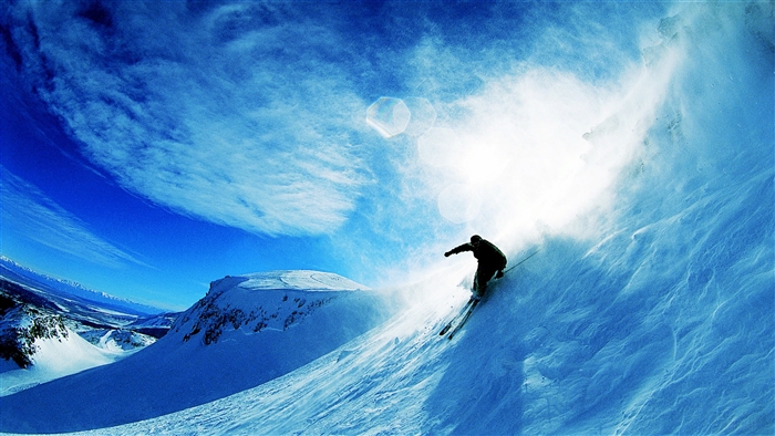 Skier skiing down a snowy mountain slope
